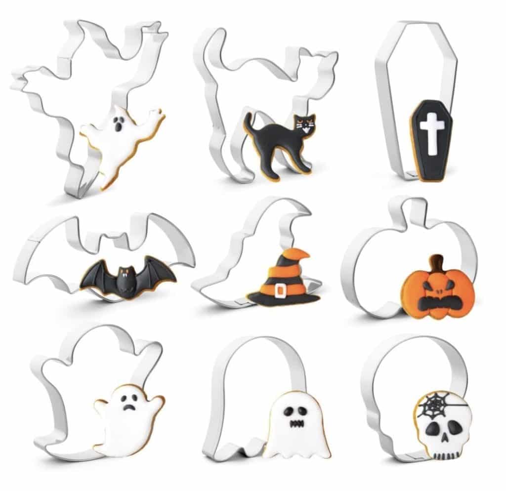 A collection of nine Halloween-themed cookie cutters is shown, featuring designs of a flying ghost, a black cat, a coffin with a cross, a bat, a witch's hat, a pumpkin, three different ghost halloween sandwiches options including standing and floating ghosts, and a skull with a spider web on its head.